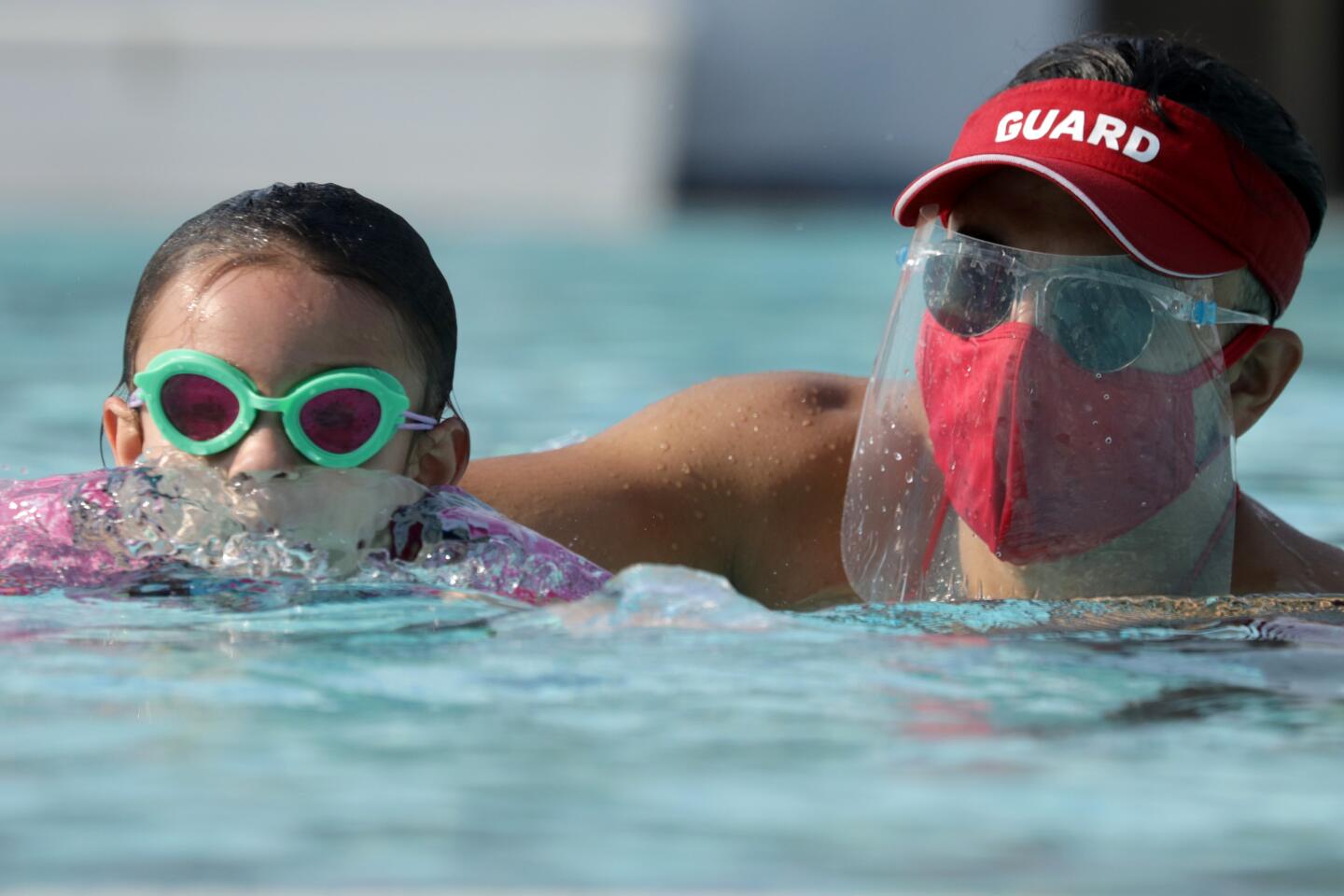 Lifeguard Michael Alfaro works with Kaila Holliday, 5, during a swim lesson in Palmdale.