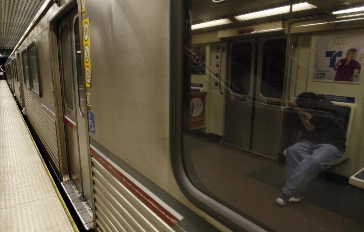 A passenger sleeps on the Metro Red Line. A blind man survived being run over by a Red Line train Thursday night after falling off the platform.