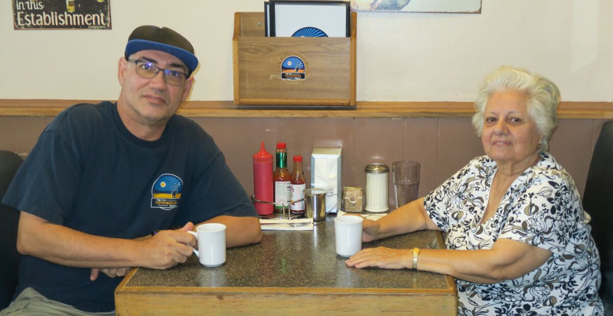Restaurant owners Ted Caplaneris and his mother Soula take a coffee break in one of the roomy booths.