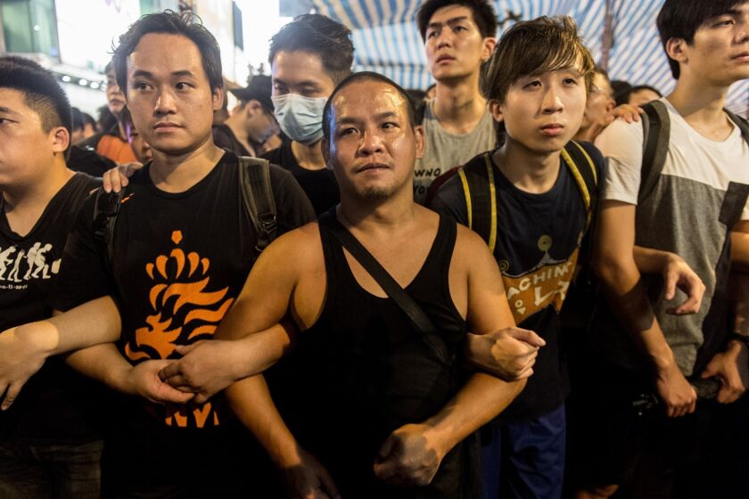 Protesters with the Hong Kong democracy movement form a chain in the Kowloon district on Oct. 3.