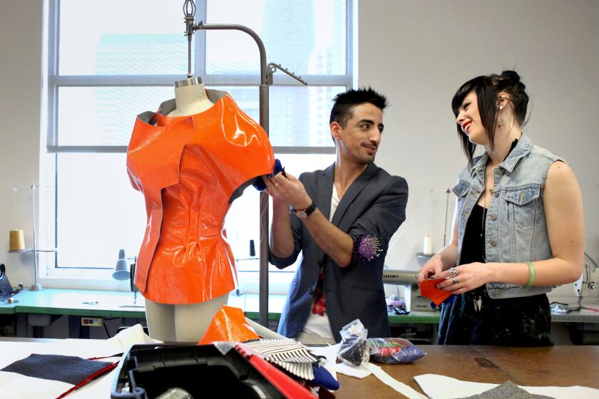 LOS ANGELES, CA: December 5, 2011 - Alejandro Ortega, left, talks with Jessica Dunn, both students, as he works on making his pieces for the Fashion Institute of Design & Merchandising's (FIDM) annual DEBUT Runway Show. Each student has to make ten different "looks" for the show. (Katie Falkenberg / For The Times)