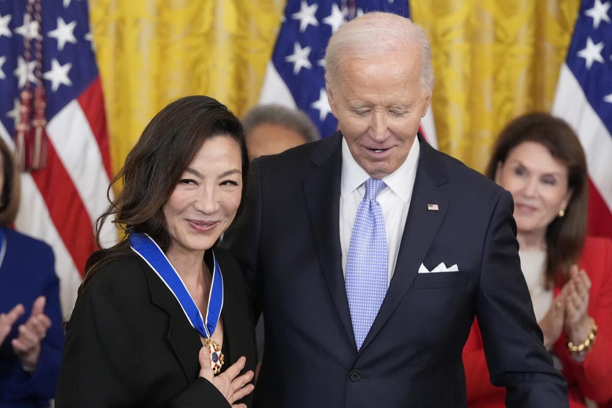 President Biden stands with Michelle Yeoh during a ceremony in the the White House.