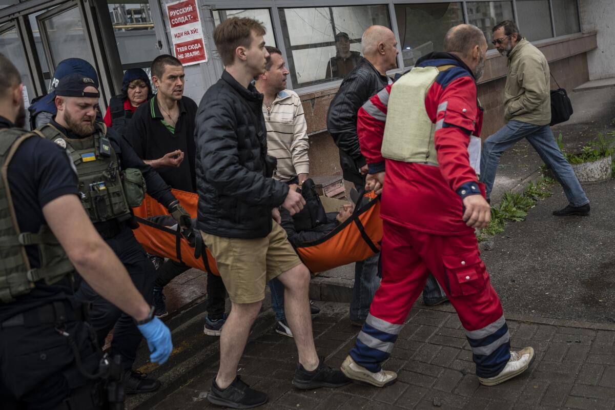 An injured man is carried on a stretcher in Kharkiv, Ukraine.