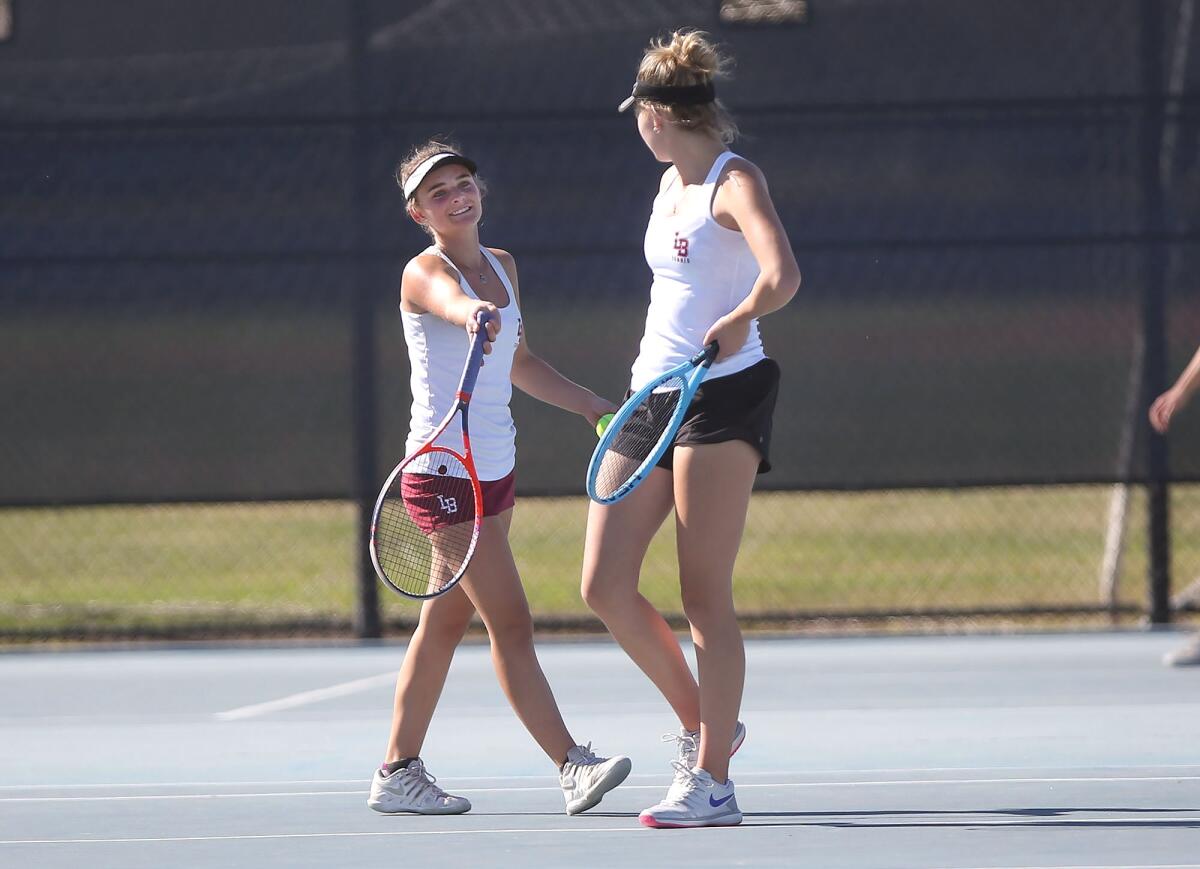 Laguna Beach doubles players Sarah MacCallum, left, and Ella Pachl talk to each other during a match against Edison's Shannon Stolaruk and Katie Kerley in the Wave League tournament on Thursday.