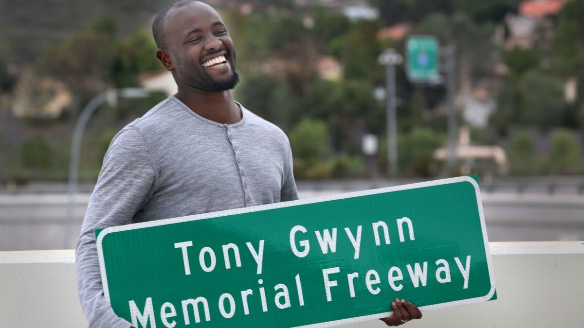 In this Oct. 19, 2015 file photo, Tony Gwynn Jr. holds a replica sign made for him and his family, presented to them by Caltrans employees, during a ceremony unveiling new freeway signs naming a section of Interstate 15 as Tony Gwynn Memorial Freeway.