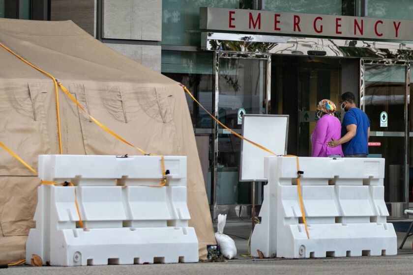 LOS ANGELES, CA - JANUARY 10: People enter UCLA Medical Center in Westwood, were there are tents outside the ER to triage and treat the overflow of patients on Sunday, Jan. 10, 2021 in Los Angeles, CA. (Jason Armond / Los Angeles Times)