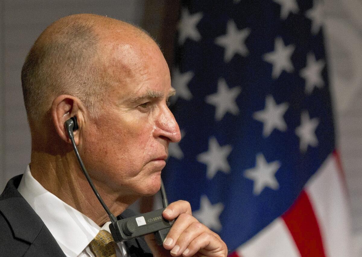 California Gov. Jerry Brown listens over translation headphones as Mexico's Secretary of Foreign Affairs Jose Antonio Meade Kuribrena speaks during a joint news conference in Mexico City on Monday.