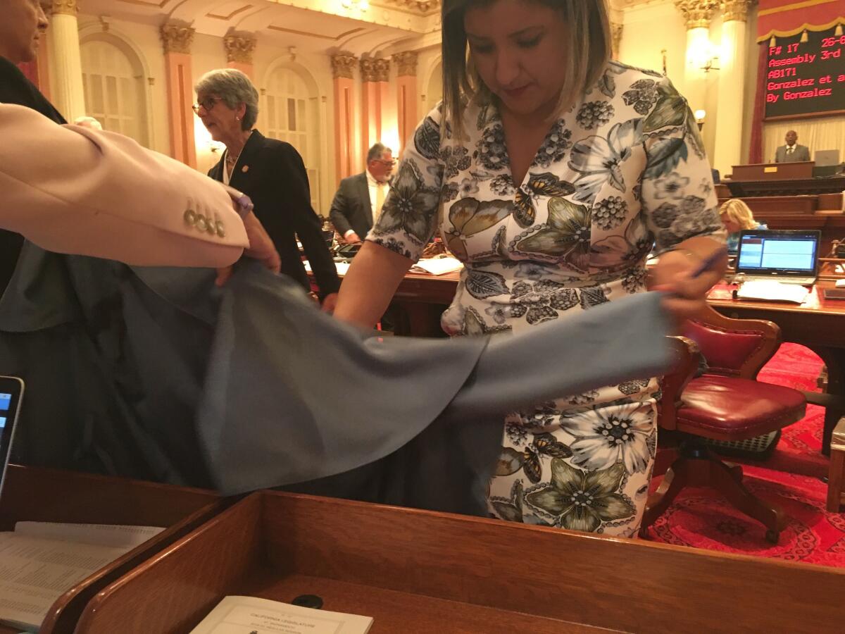 Sen. Melissa Hurtado inspects a jacket after it was splattered with blood