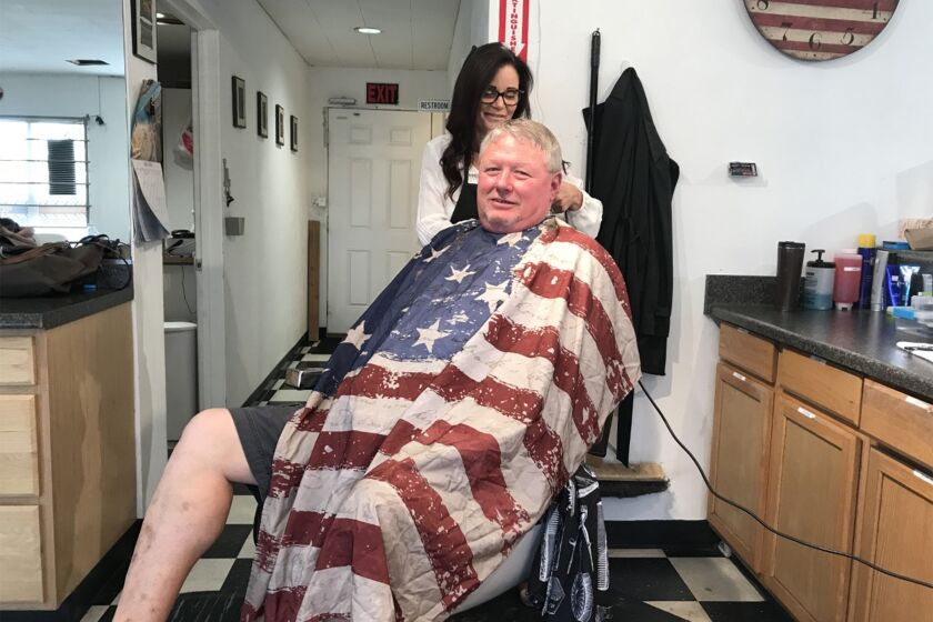 At the Norris Barbershop in Oildale, Danika Jeter cuts Lonnie Munds' hair. He's thinking about moving to Texas. California is too expensive.