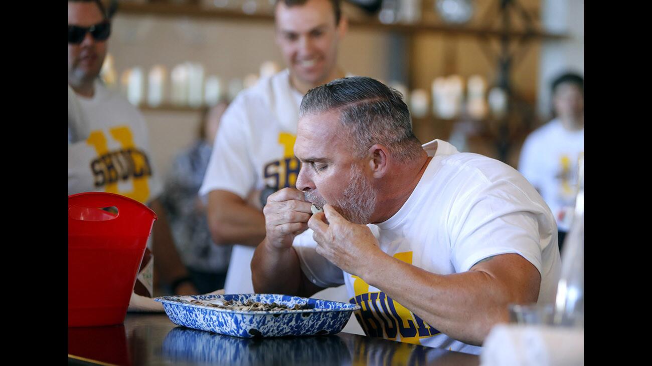 Jason Raymond from the Huntington Beach Fire Dept. uses a two-handed technique to eat as many oysters as possible at the Third Annual Shuck It Event, held at Ways & Means Oyster House, in Huntington Beach, on Saturday, Jan. 20, 2018. Each team member had sixty seconds to eat as many oysters as they could without dropping any on the floor. The team from the HBPD team won with 97 oysters, this Fire Dept. team came in second place with 73 oysters eaten and third place went to the lifeguards Marine Safety team, who downed 53 of the shellfish. The head-to-head oyster-eating contest was done for charity.