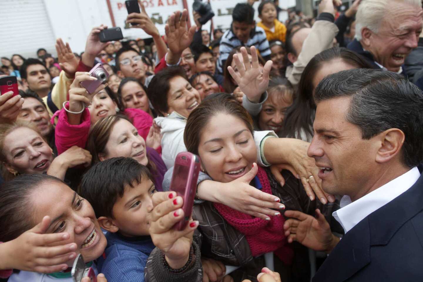 Enrique Pena Nieto, presidential candidate of the Revolutionary Institutional Party, or PRI, greets supporters after casting his vote in Atlacomulco, Mexico.