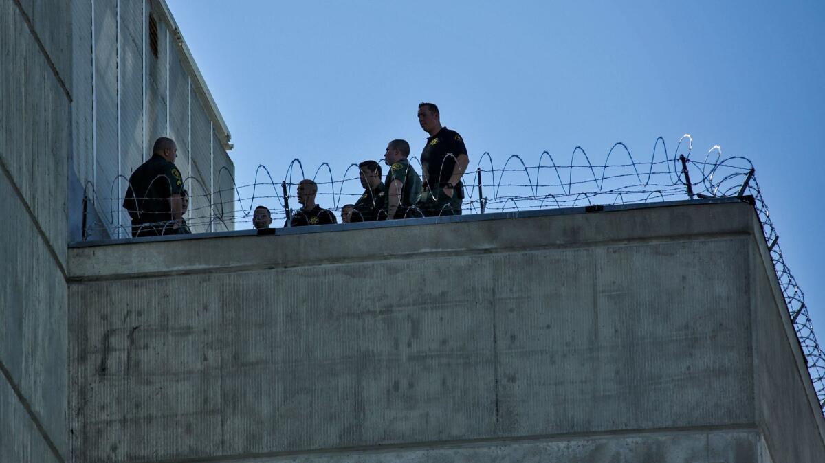 Orange County sheriff's investigators inspect the roof of the Central Men's Jail in Santa Ana in 2016 after three inmates escaped using a makeshift rope of knotted bedsheets and cloth.