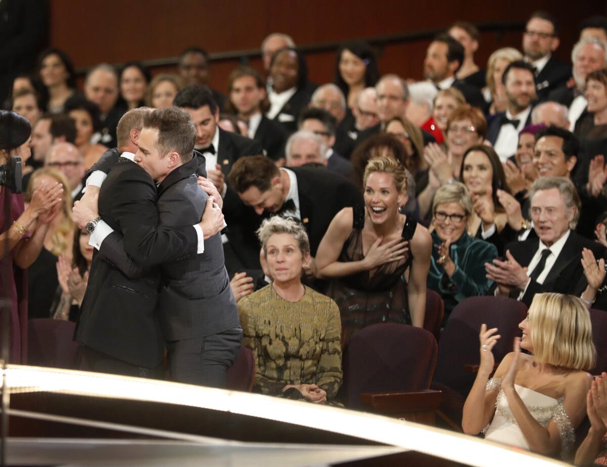 Sam Rockwell and Woody Harrelson embrace after Rockwell wins the supporting actor Oscar at the 90th Academy Awards.