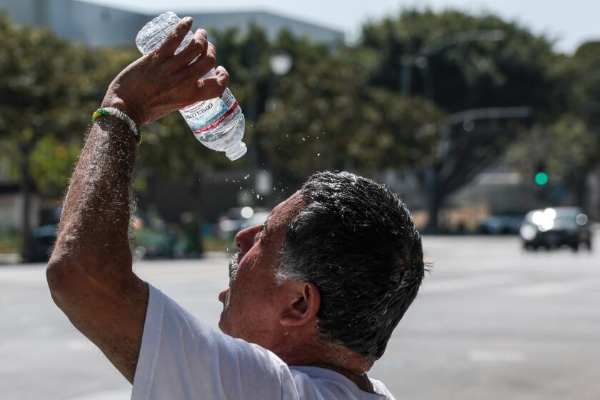 Los Angeles, CA - July 28, 2026: Former LAPD officer Gabriel Cabrera cools off while taking a break from demonstrating in front of police headquarters on a hot day in Los Angeles, CA on Tuesday, July 28, 2026. (Robert Gauthier/Los Angeles Times)