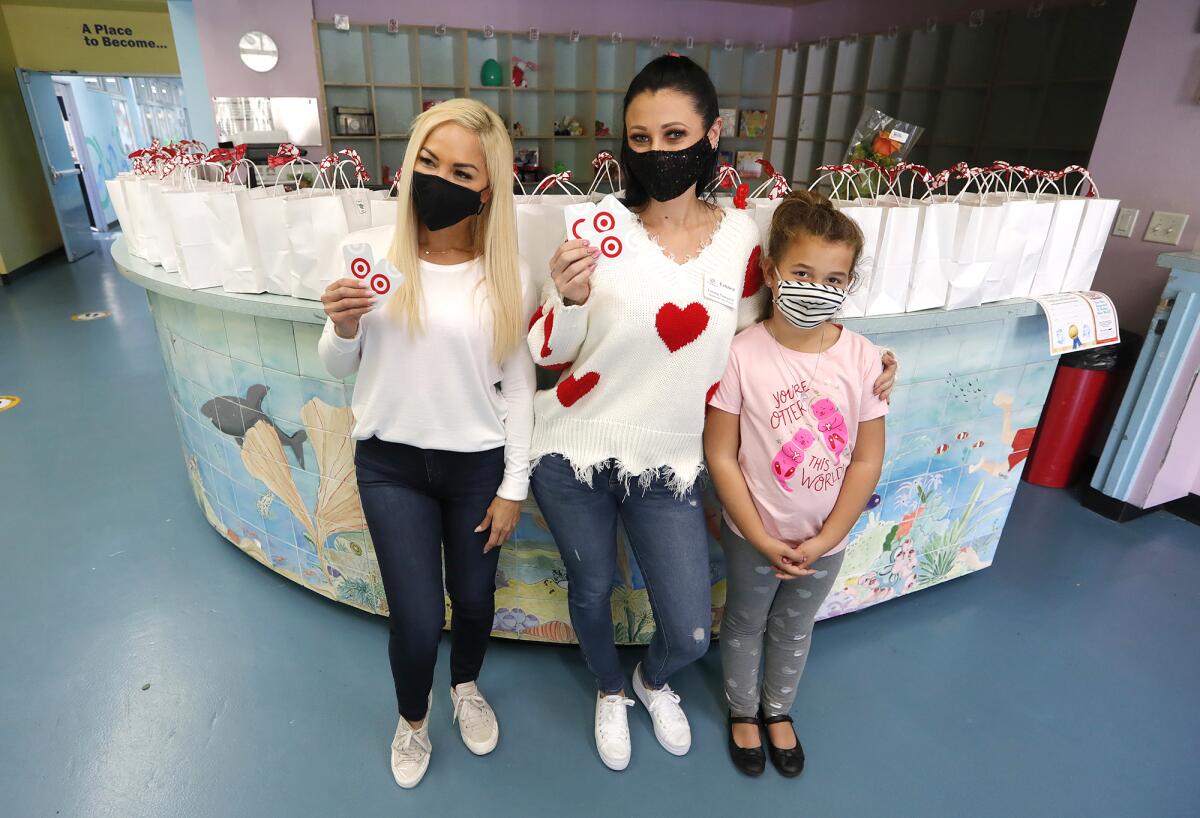Merry Tungka, Linnea Newquist, and McKinley Costales, from left, at a Valentine's Day giveaway at the Boys & Girls Club.