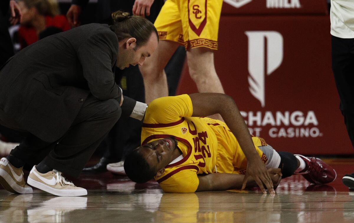 A team trainer tends to USC forward Josh Morgan during the first half of USC's win over Washington State.