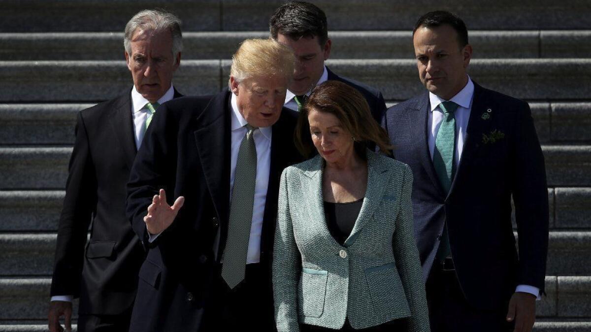 President Trump talks to House Speaker Nancy Pelosi as they leave the Capitol following a St. Patrick's Day observance in March.