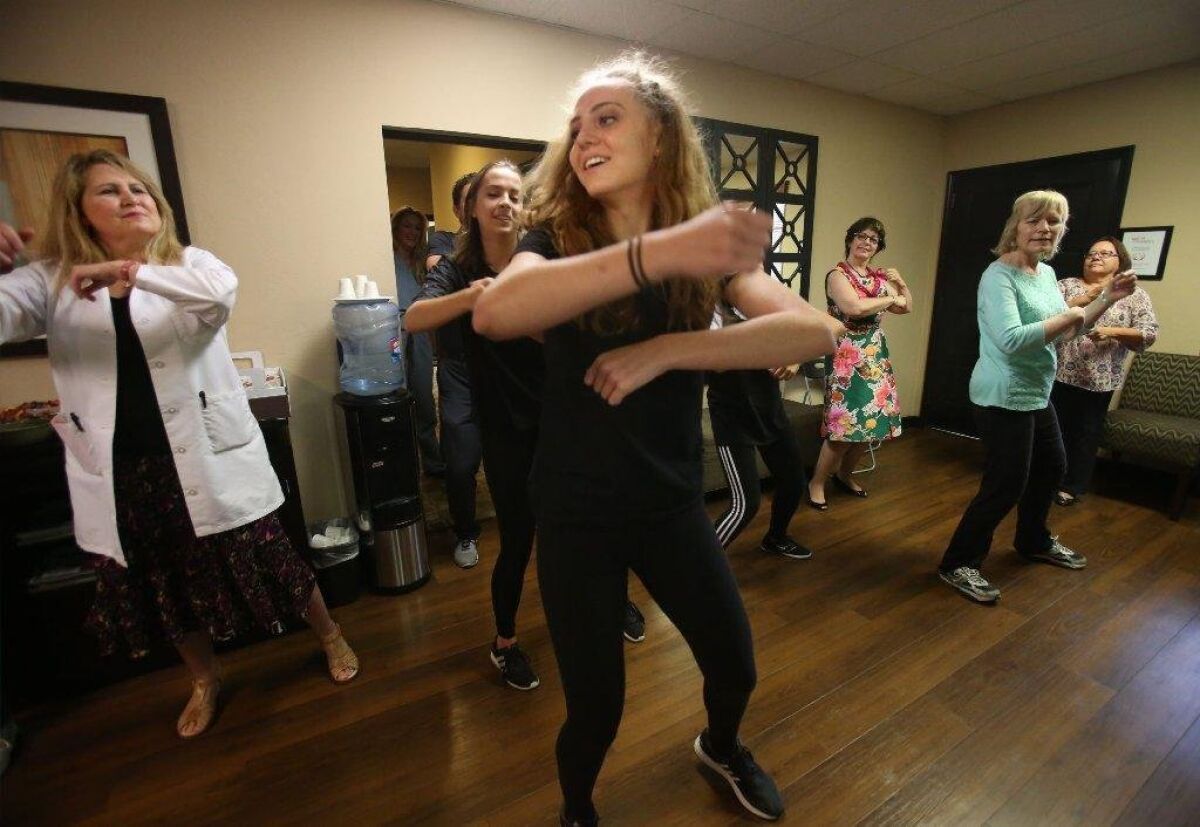 Sarah Ludington, 16, leads a group in a dance routine at North Coast Cardiology. At left is her mother Dr. Katherine Ludington. Behind her are fellow Torrey Pines High student Rebekah Hardeman, and visitors Theresa Bell and Christina Tillotson, in green.