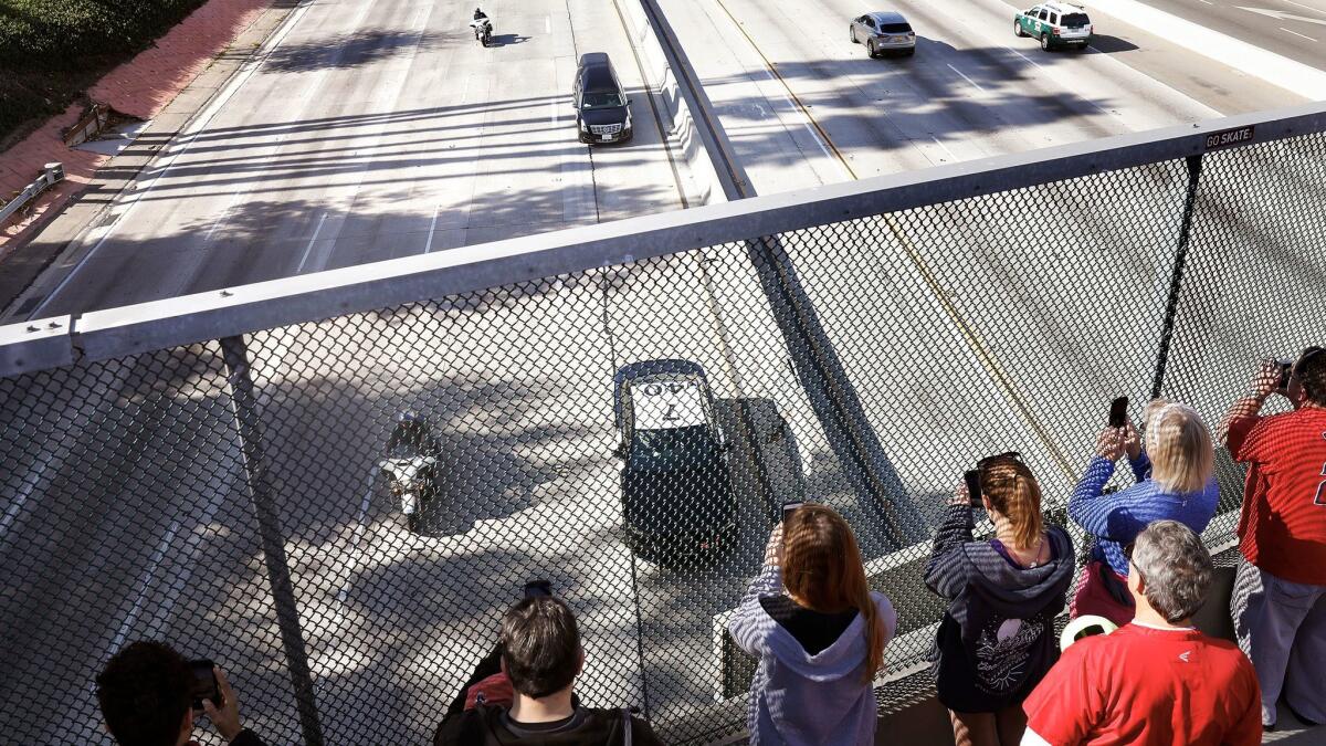 People watch from an overpass in Burbank as a procession for fallen Cal Fire engineer Cory Iverson, 32, passes through en route to San Diego.