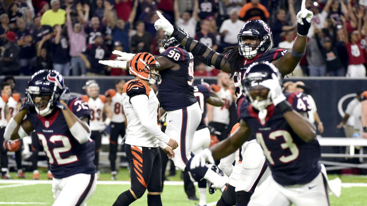 Texans players celebrate after Bengals kicker Randy Bullock, center left, missed a field goal as time expired Saturday night.