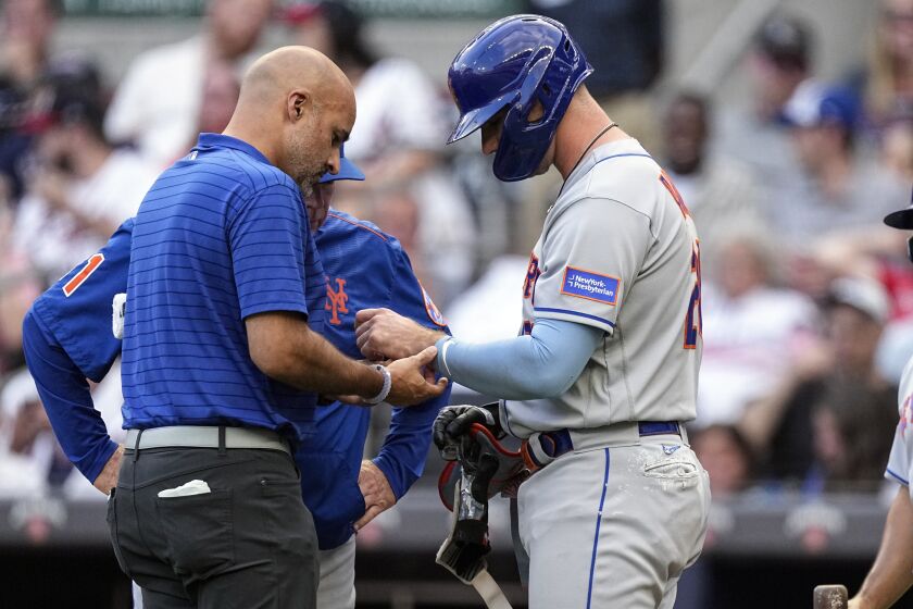 A member of the New York Mets training staff checks first baseman Pete Alonso (20) hand after he was hit by a pitch from Atlanta Braves starting pitcher Charlie Morton (50) in the first inning a baseball game against the Atlanta Braves, Wednesday, June 7, 2023, in Atlanta. (AP Photo/John Bazemore)