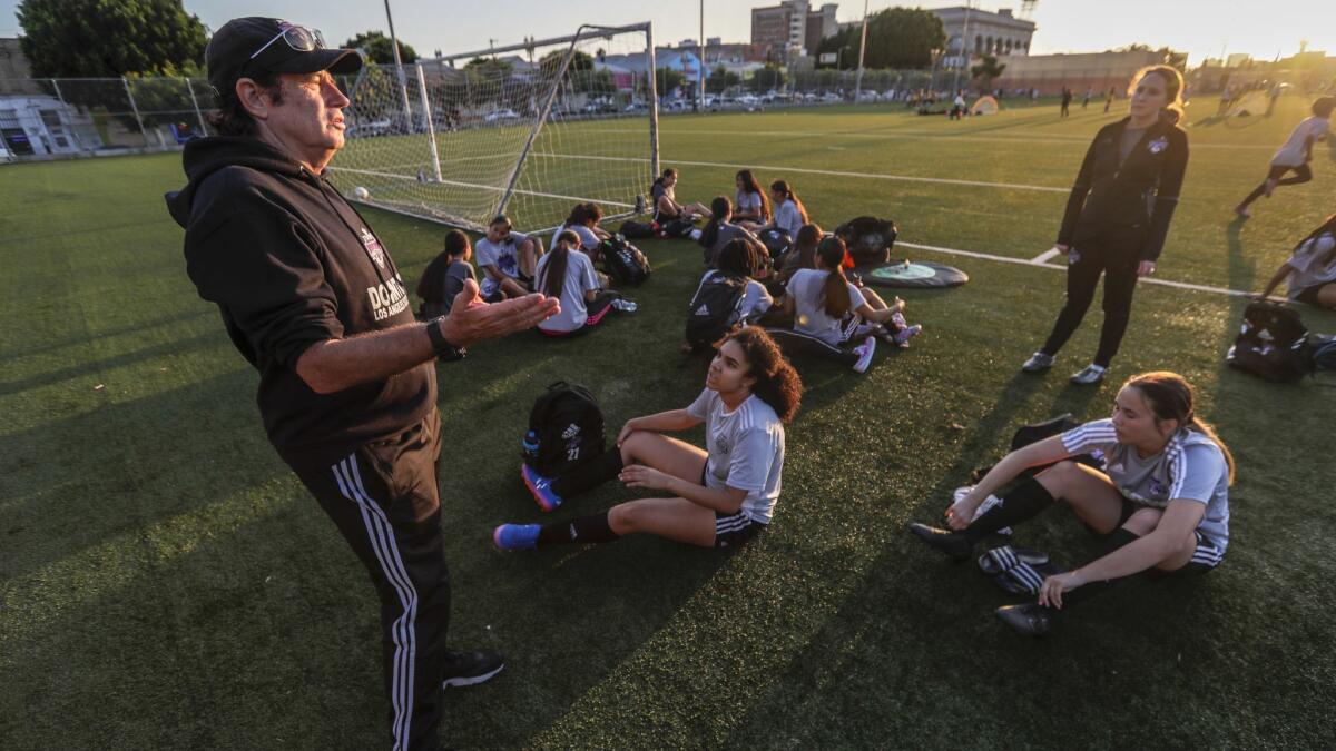 Downtown Los Angeles Soccer Club coach Mick Muhlfriedel talks with players during practice at Liechty Middle School. His mission is to empower young Latinas through soccer, helping them break the cultural barriers that often keep them from realizing their athletic dreams.