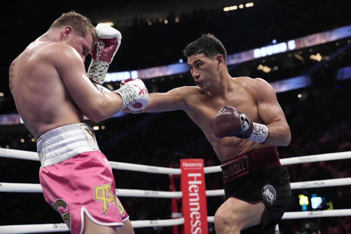 Dmitry Bivol, right, throws a punch against Canelo Álvarez during their light heavyweight fight in Las Vegas on Saturday.