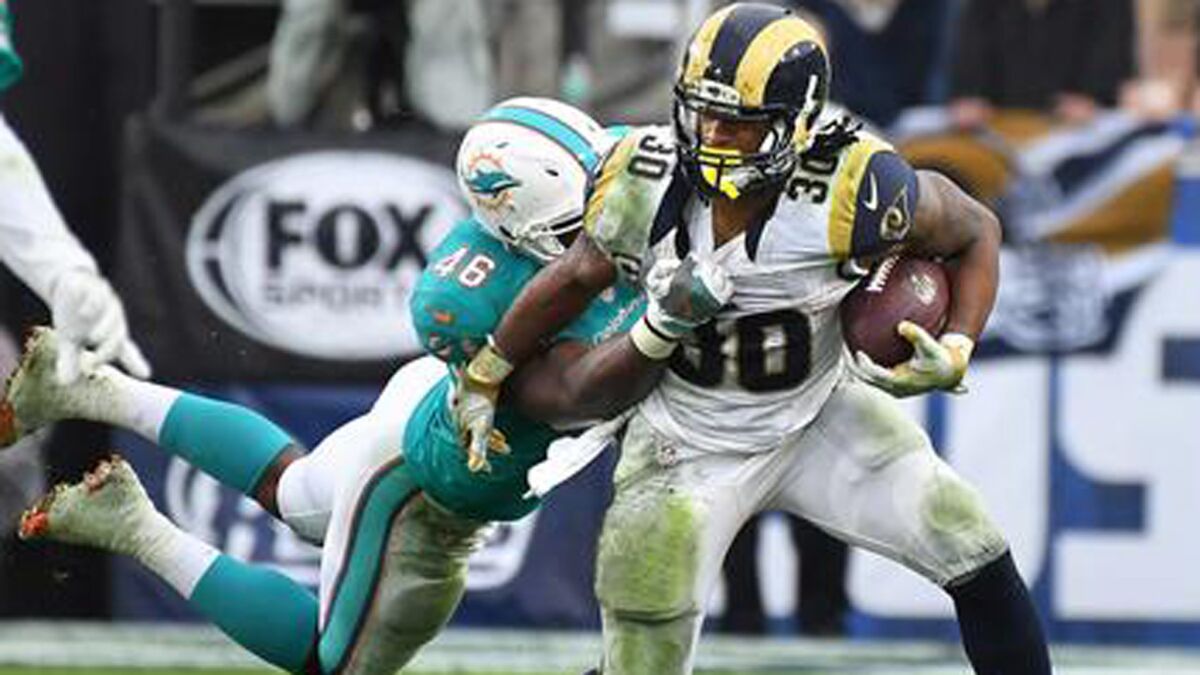 Rams running back Todd Gurley tries to escape Dolphins linebacker Neville Hewitt in a 2016 game.