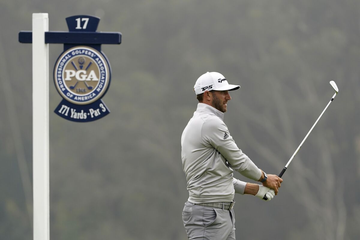 Dustin Johnson watches his tee shot on the 17th hole during the third round of the PGA Championship golf tournament at TPC Harding Park Saturday, Aug. 8, 2020, in San Francisco. (AP Photo/Charlie Riedel)
