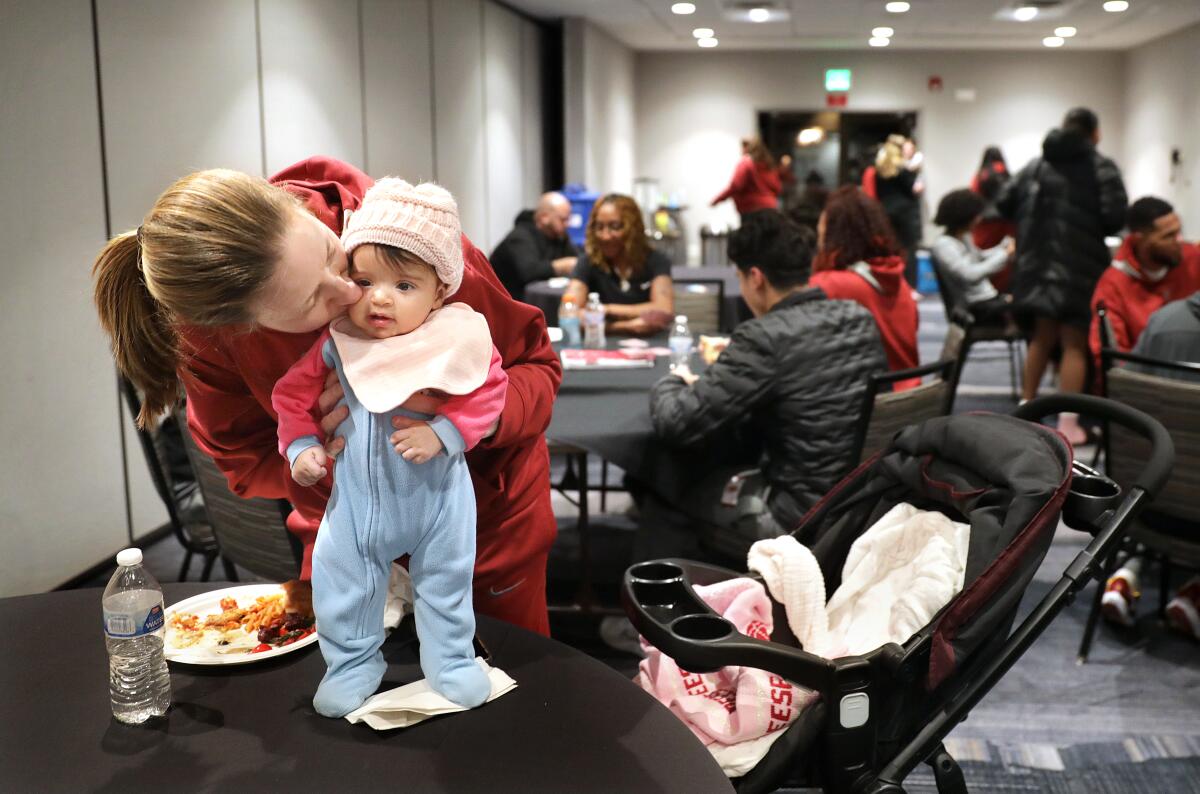 USC women’s basketball head coach Lindsay Gottlieb kisses her daughter Reese during a team dinner while on the road.