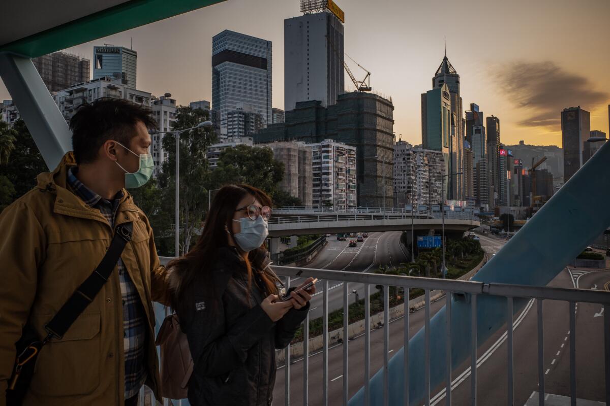 People wearing protective masks walk on a pedestrian bridge on Jan. 29 in Hong Kong.