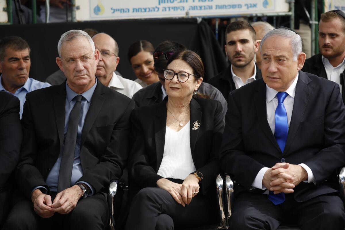 Blue and White party leader Benny Gantz, left, Supreme Court Chief Justice Esther Hayut and Prime Minister Benjamin Netanyahu.