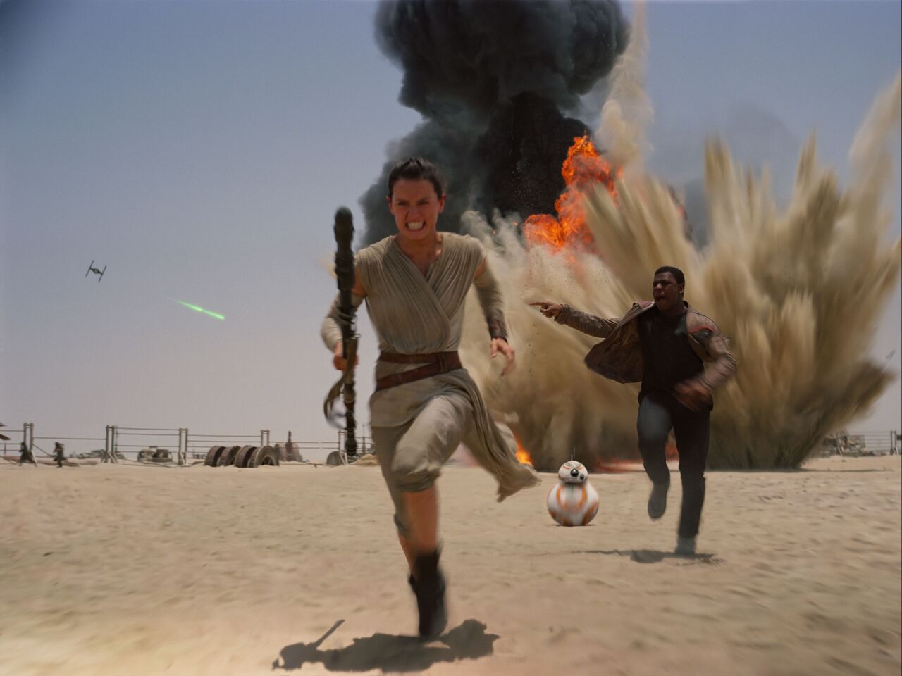Rey (Daisy Ridley), left, the pint-sized droid BB-8, and Finn (John Boyega) make a break for it in a scene from "The Force Awakens."