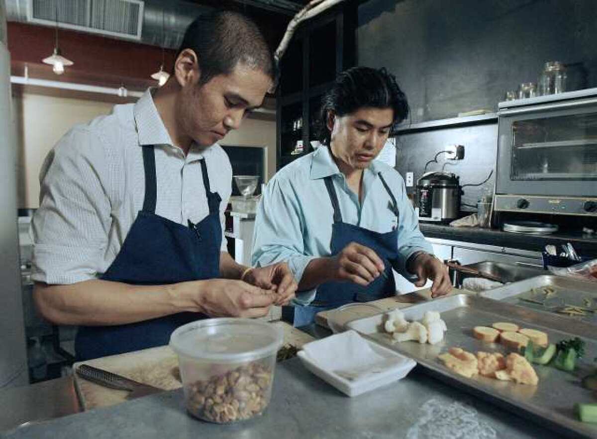 Todd Chang, cooks apprentice, and Chef Gary Menes at Le Comptoir in Glendale prepare for dinner. The restaurant is in the historic Bekins Storage building.