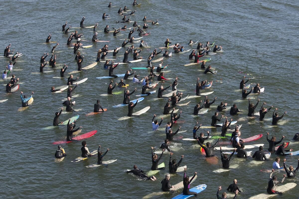 Hundreds of surfers paddle into the waves Jan. 8 in memory of Sean Collins, a pioneering wave forecaster for surf.com who died Dec. 26th of a heart attack.