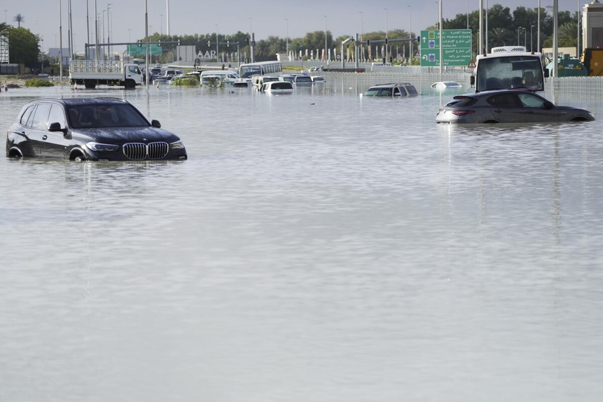 Vehicles sit abandoned in floodwater covering a major road in Dubai.