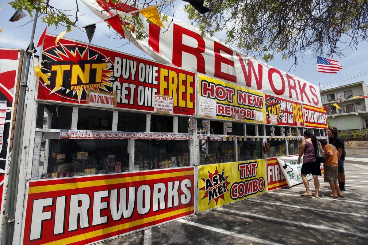 A family buys fireworks at a TNT Fireworks stand in the city of Monterey Park. The Los Angeles Fire Department is urging people not to set off their own displays.