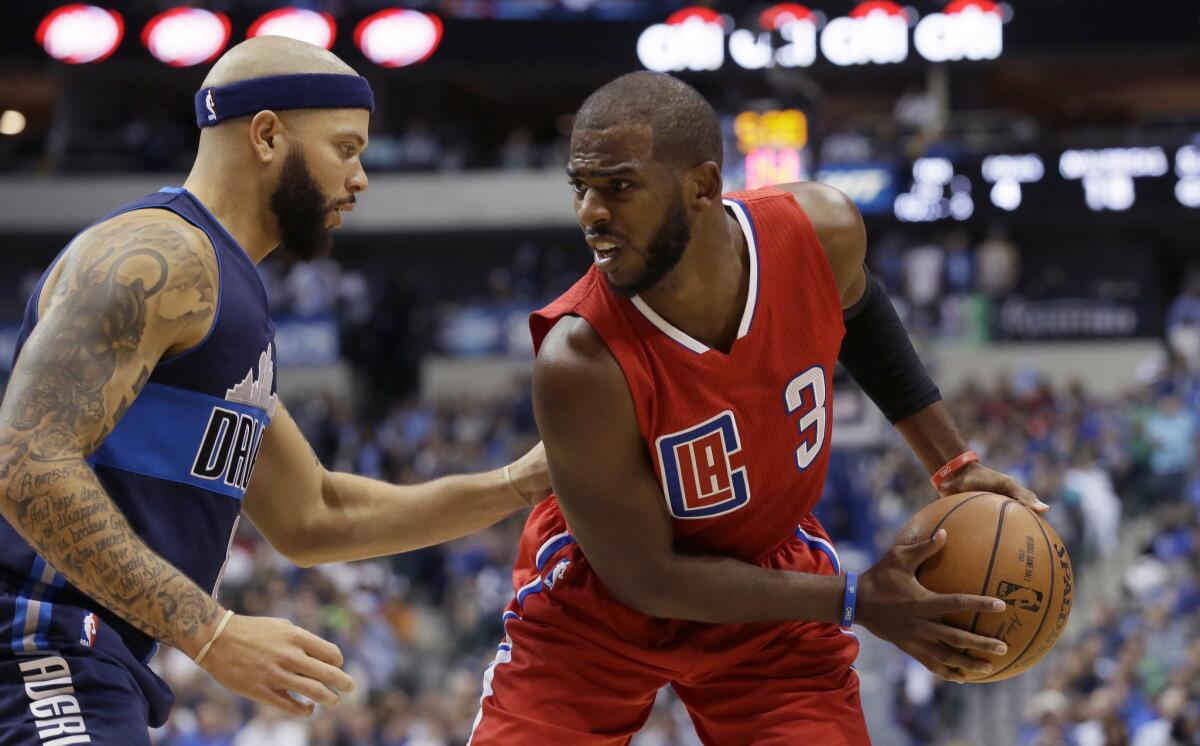 Clippers guard Chris Paul is defended by Mavericks guard Derron Williams during the first half of a game on Nov. 11.