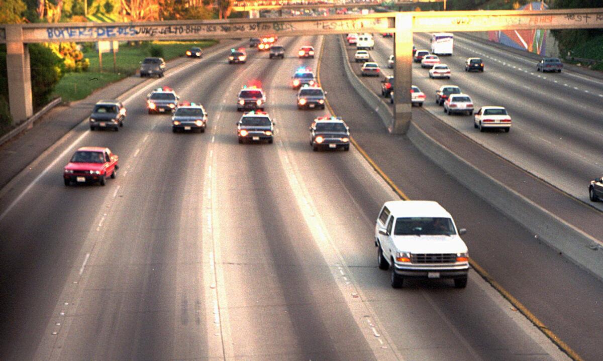 In this June 17, 1994, photo, a white Ford Bronco, driven by Al Cowlings carrying O.J. Simpson, is trailed by Los Angeles police cars as it travels on a Southern California freeway in Los Angeles.