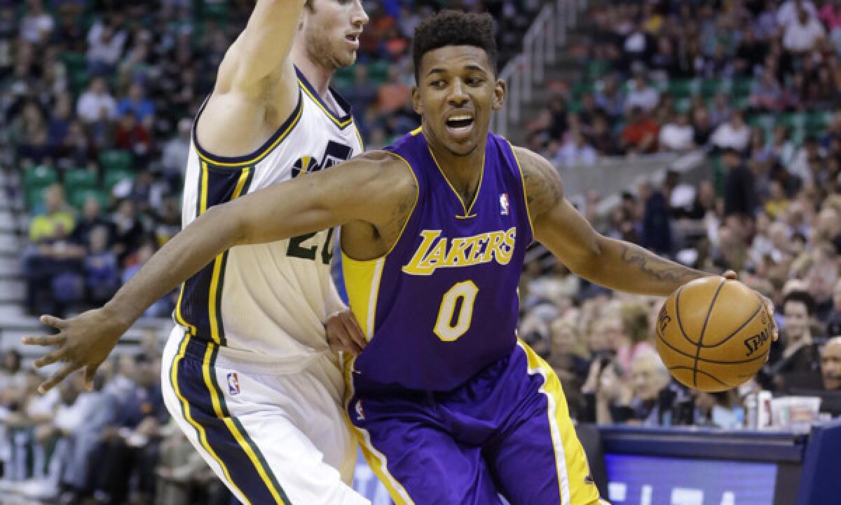 Lakers small forward Nick Young, right, drives around Utah Jazz guard Gordon Hayward during the first quarter of Monday's game.