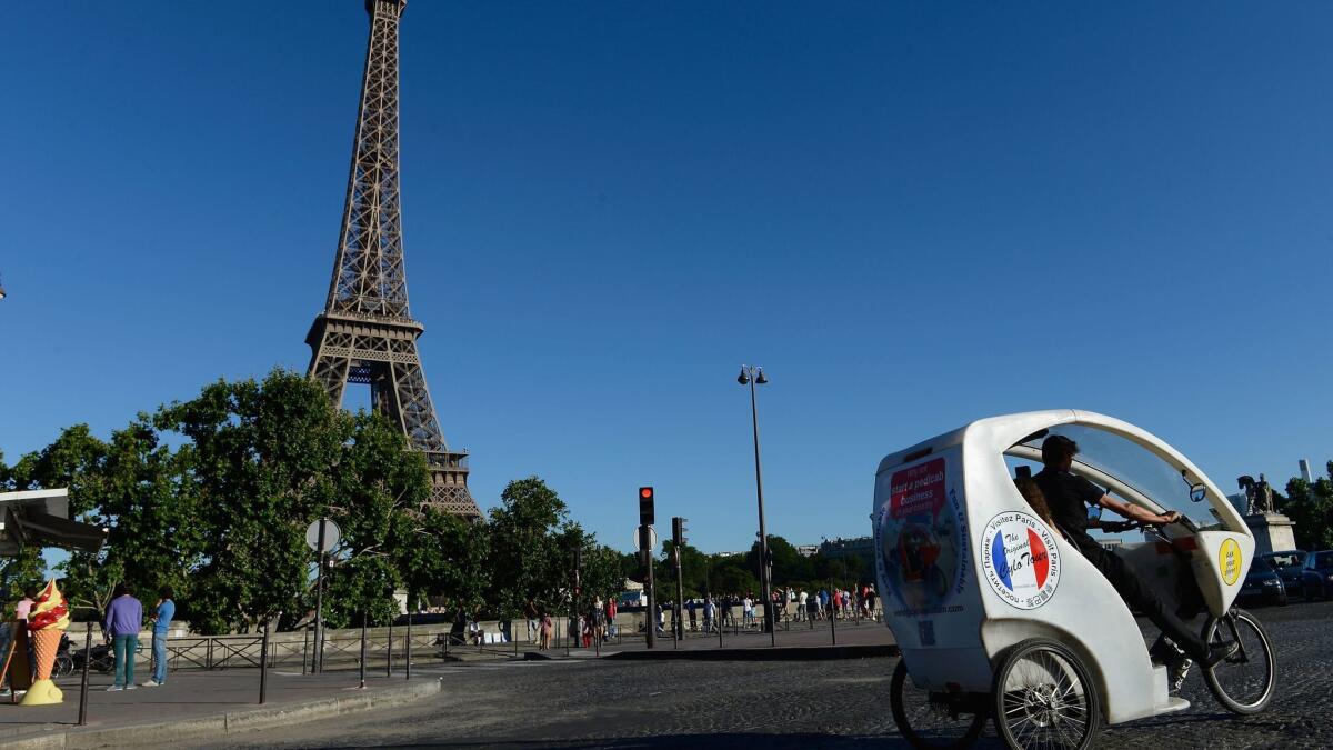 Tourists in Paris ride in a bicycle taxi past the Eiffel Tower. In the first 11 months of 2017, the number of Americans traveling internationally grew 9.6% over the same period in 2016.