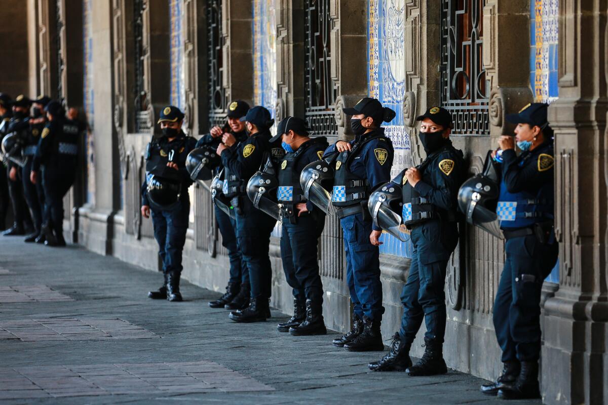 Police officers stand guard outside a Mexico City municipal building on Thursday. While most countries and major cities have ordered a lockdown to halt COVID-19 spread, Mexico's president has not called for strict measures.