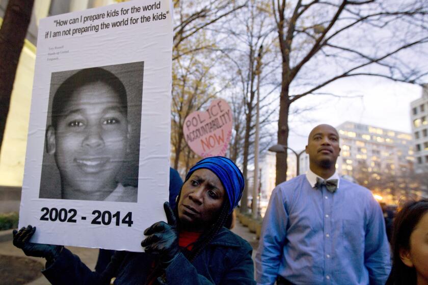 FILE - In a Monday, Dec. 1, 2014 file photo, Tomiko Shine holds up a picture of Tamir Rice during a protest in Washington, D.C. Timothy Loehmann, the Cleveland police officer who shot and killed Tamir Rice and ultimately was fired, resigned Monday, July 1, 2024, from a police department in White Sulphur Springs, W.Va. White Sulphur Mayor Kathy Glover said Loehmann had been hired as a probationary officer at the recommendation of the small town’s police chief. (AP Photo/Jose Luis Magana, File)