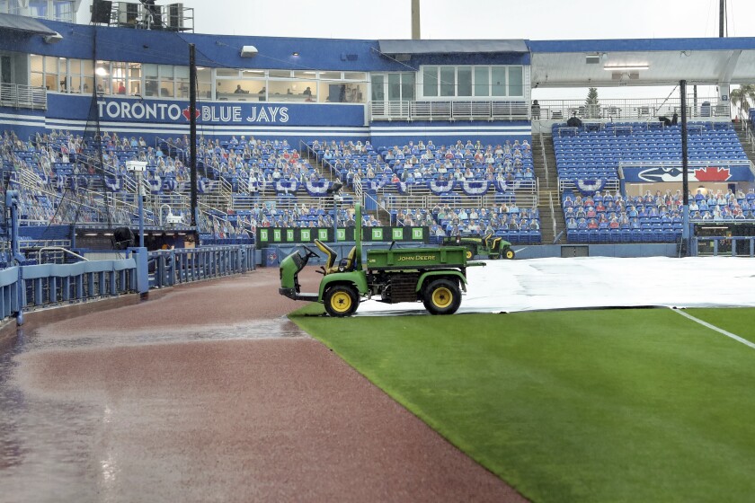 Rain delays the start of the baseball game between the Los Angeles Angels and Toronto Blue Jays Sunday, April 11, 2021, in Dunedin, Fla. (AP Photo/Mike Carlson)