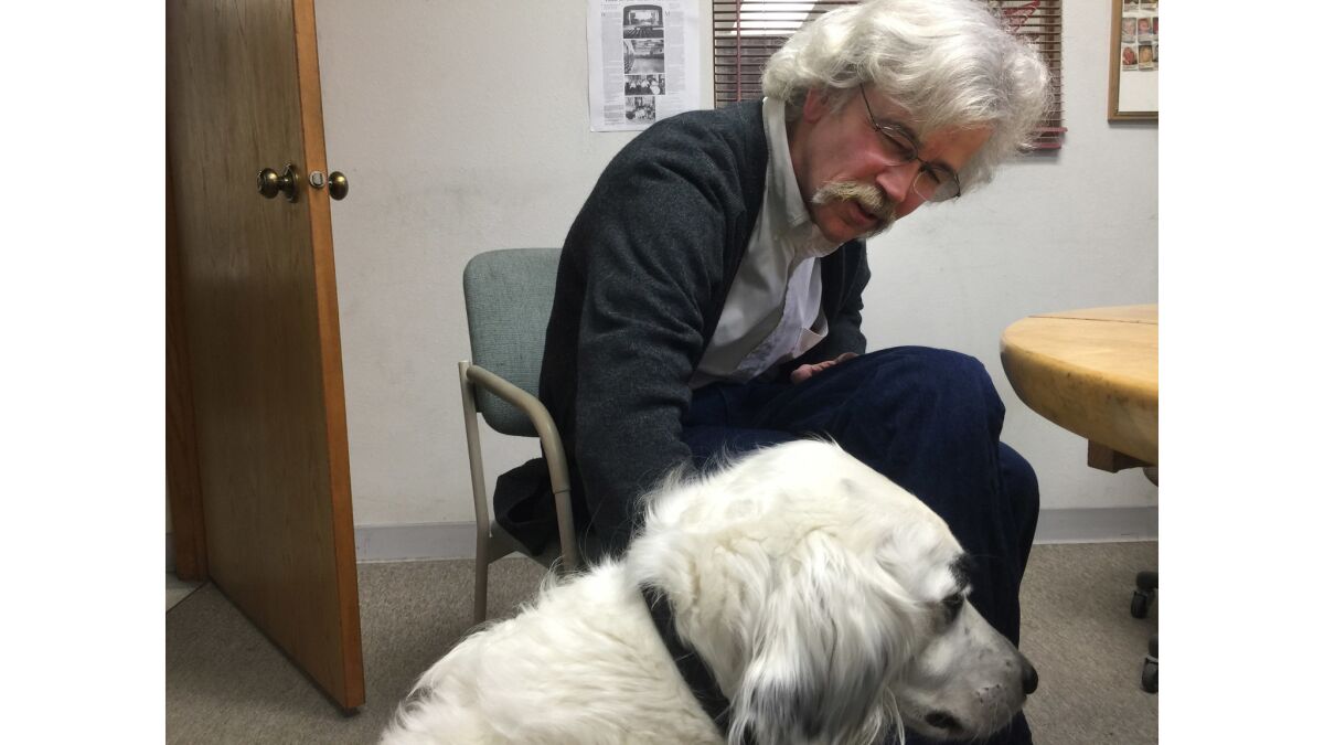 Art Cullen, 59, editor of the Storm Lake Times in Storm Lake, Iowa, with the black-and-white "newspaper dog" Mabel, who doubles as the Cullen family dog.
