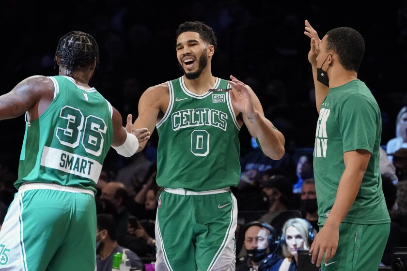 Boston Celtics forward Jayson Tatum (0) celebrates after scoring with guard Marcus Smart (36) during the first half of an NBA basketball game against the Brooklyn Nets, Tuesday, Feb. 8, 2022, in New York. (AP Photo/John Minchillo)