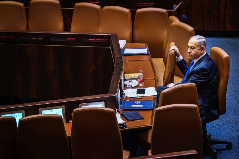 Outgoing Prime Minister Benjamin Netanyahu takes a look around the empty seats as members of the Knesset, Israel's parliament, step out for a break before returning to cast their vote of confidence to empower the new coalition government and unseat Netanyahu on Sunday. (Marcus Yam / Los Angeles Times)