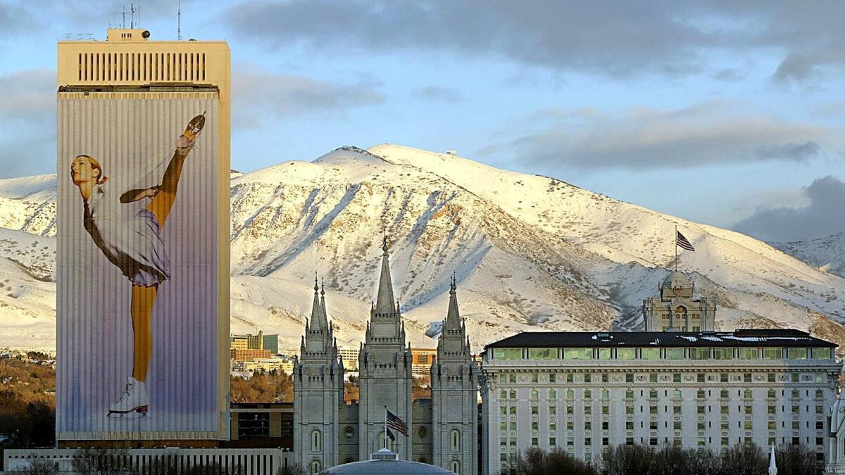 In this file photo taken on January 22, 2002 Downtown Salt Lake City is bathed in the evening sunlight as an Olympic sports banner drapes the 26 story Mormon church office building with the Mormon temple in the center.