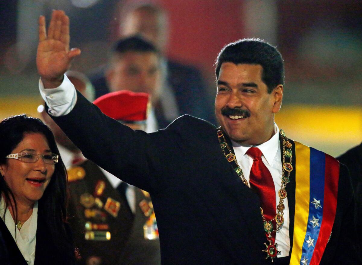 Venezuelan President Nicolas Maduro, with his wife, waves upon arrival for an independence day parade in Caracas on Friday.