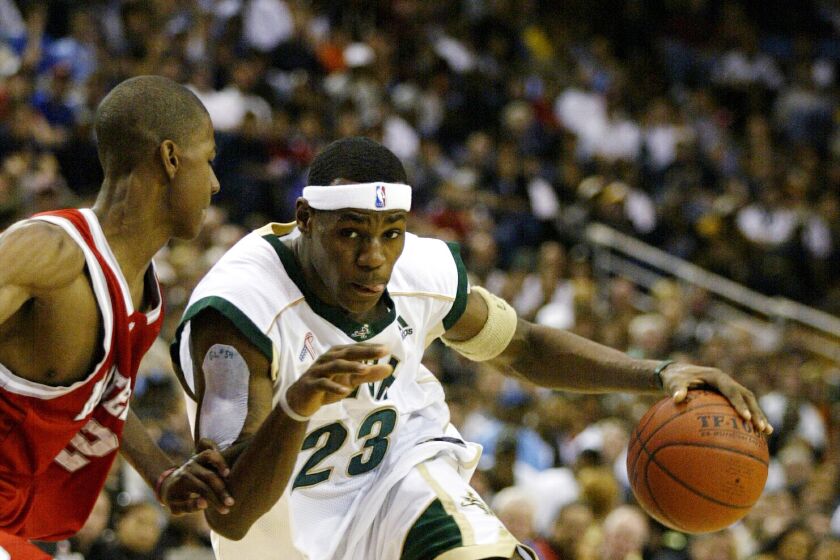 WESTWOOD, CA – JANUARY 4: LeBron James @@#23 of the St. Vincent–St. Mary Fighting Irish drives against D.J. Strawberry.
